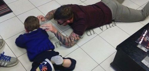 Il barbiere si sdraia a terra per tagliare i capelli al bambino autistico che ha paura delle forbici